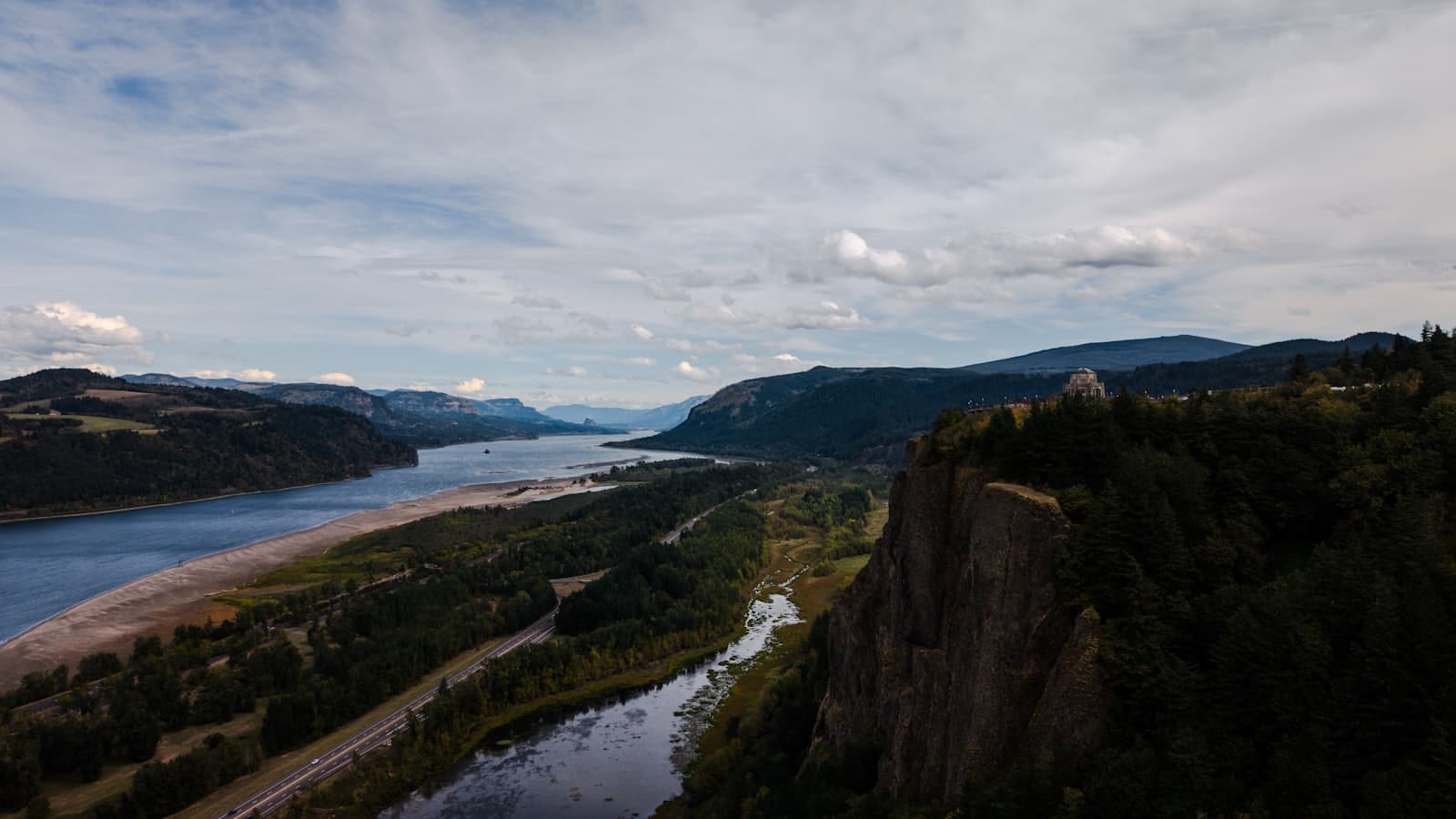 A wide river winding through a forested mountain valley watershed